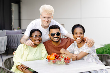 Multinational friends having fun in outdoor cafe in summer time