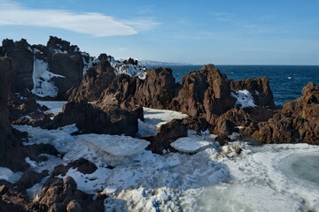Russia. Far East, Kuril Islands. Very hard and sharp basalt rocks along the coast of the Sea of...
