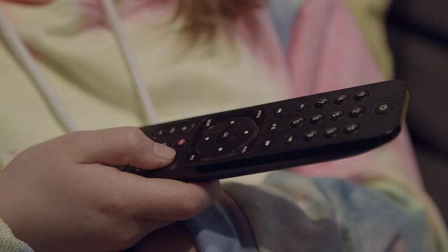 Ni&ntilde;a mirando la TV, mano con mando