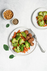 Healthy food broccoli, carrots and vegetable meatballs on a plate top view on a white background with copy space