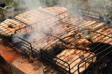 Coil of spicy beef sausage grilling on a fire. Delicious grilled sausage. Spirals sausage grilling on a BBQ