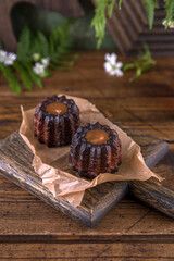 Portion of canele dessert on wooden background