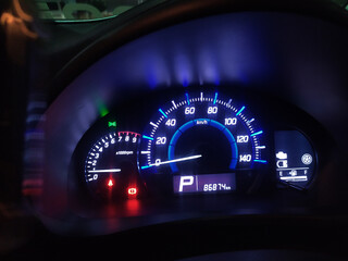 Illuminated Car Dashboard at Night Speedometer, Tachometer, and Fuel Gauge Display