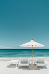 Fototapeta premium Summer concept of umbrellas and wooden deckchairs on a white sandy beach with a view of the blue sea and clear sky.