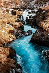 A river flowing through a snowy canyon with rocky terrain