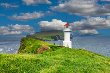 White lighthouse standing on green grass field