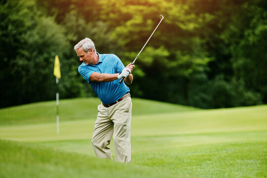 Senior man, golf stroke and sports with wellness, retirement and playing with grass field. Active, pensioner and mature guy with club, active and hobby with weekend break, motion and skills for game