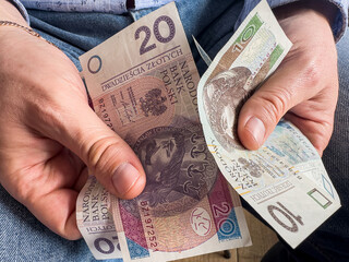 Man counts 10 20 zloty polish banknotes, saving concept
