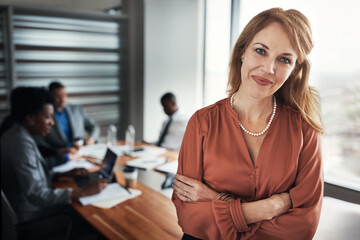 Office, meeting and portrait of business woman with crossed arms for planning, collaboration and teamwork. Corporate, professional and happy manager with workers for coworking, feedback and training