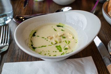 Truffle mushroom soup with spring onion sauce in ceramic bowl