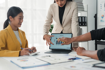 Business team analyzing financial data on tablet during meeting