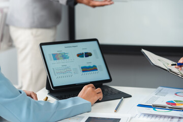 Business team analyzing financial data using digital tablet during corporate meeting