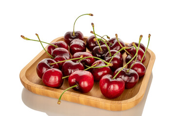 Several sweet cherries on a bamboo plate, macro, isolated on white background.