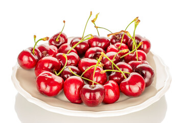 A few sweet cherries on a ceramic plate, macro, isolated on a white background.