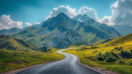 Fototapeta premium Highway winding through green mountain fields under a summer sky with fluffy clouds