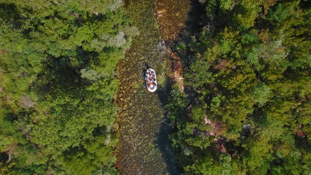 Rafts floating down the Cetina River surrounded by dense green trees in summer forest of Croatia