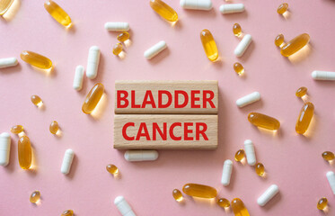 Bladder Cancer symbol. Concept word Bladder Cancer on wooden blocks. Beautiful pink background with pills. Medicine and Bladder Cancer concept. Copy space