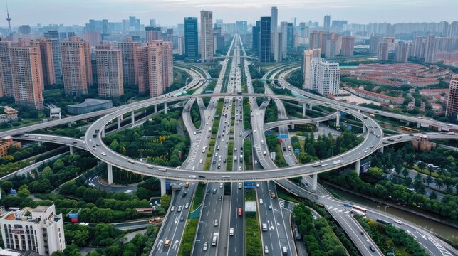 An aerial photo of a vast highway interchange with cars merging and diverging on multiple lanes against a backdrop of a modern cityscape.