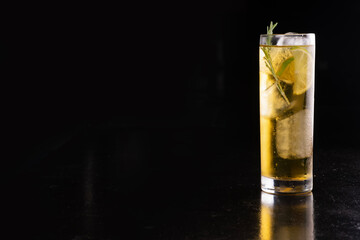 cocktail long drink glass with whiskey and energy drink and ice isolated in corner black background