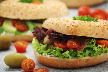 Sesame bagels with tomatoes, ham and olives