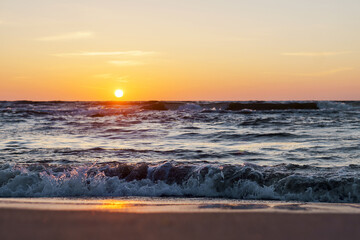 Sunset over the sea. Reflection of sunlight in the sea waves. The sky in the sunset rays. Baltic Sea.