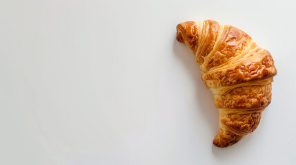 Golden Brown Croissant Displaying Flaky Layers On A Light White Background