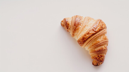 Golden Croissant With Flaky Texture On A Minimalist White Surface