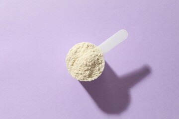 Spoon with protein on colored background