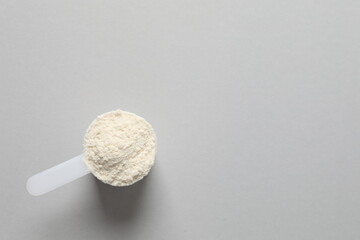 Spoon with protein on gray background