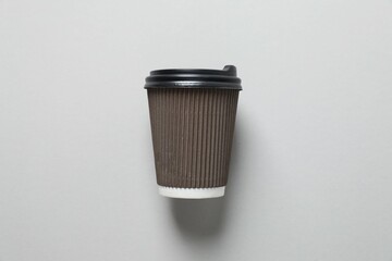 Paper cup of coffee on gray background