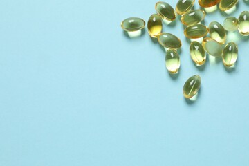 Omega-3 capsules on color background with copyspace. Healthcare, wellbeing and supplements.