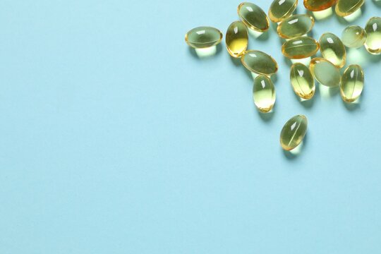 Omega-3 capsules on color background with copyspace. Healthcare, wellbeing and supplements.