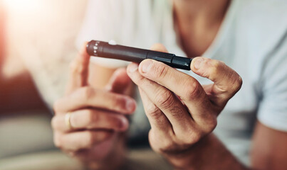 Diabetes, lancet pen and hands of person in home for blood sugar, monitor insulin and glucometer test. Healthcare, medical and finger with needle for glucose, diabetic treatment and hypoglycemia