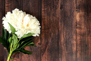 Bouquet of beautiful peonies on an old wooden background,Abstract flower arrangement, flat lay,summer banner with place for text.Creative modern bouquet. Greeting card and holiday concept 
