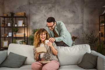 Surprised girlfriend hold gift read greeting card from her boyfriend © Miljan Živković