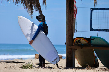 surfer holding a surfboard on the beach