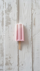 Soft pink popsicle on a white wooden background. Summer background