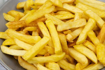vue d'un plat de frites, en gros plan, sur une table