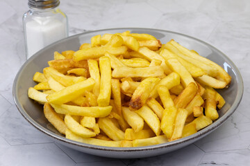 vue d'un plat de frites, en gros plan, sur une table