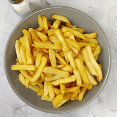 vue d'un plat de frites, en gros plan, sur une table