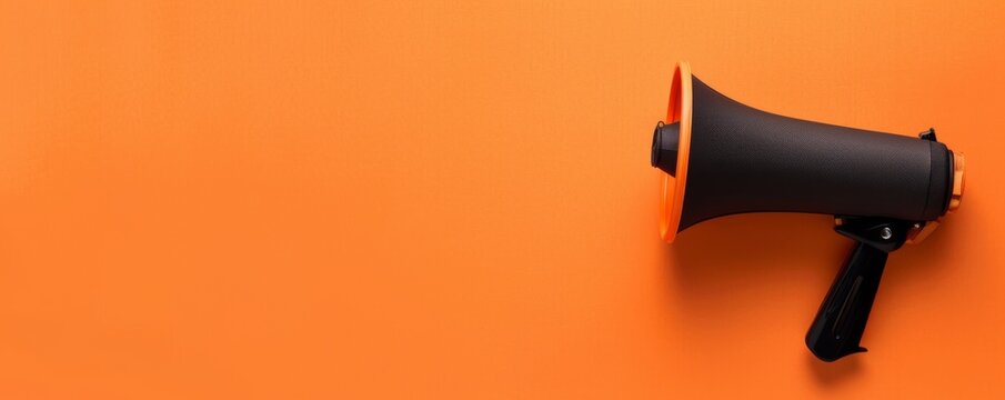 This is a business concept image with a paper cup megaphone and an orange background with copy space. This is an attention concept image. It is a minimalist flat lay image.