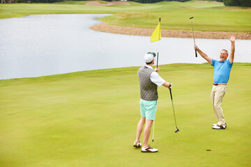 Men, golf and win with celebration in game as members in club for health, success in business. Male...