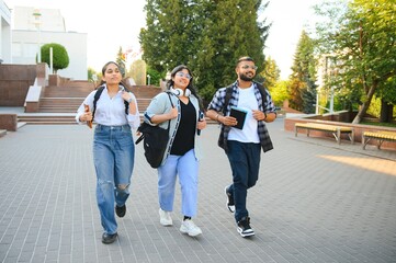 Obraz premium Three international students standing and holding a books