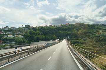 A Winding Highway Bridge Leading to a Tunnel in a Forested Area