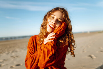 Portrait of positive young female in warm clothes smiling and looking at camera. Spring time. Travel, weekend, relax and lifestyle concept.