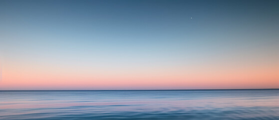 Fototapeta premium Serene Ocean Horizon at Sunset with Gentle Ripples.