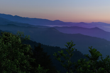 Landscape horizon line in the mountains, orange sunset and blue mountains.
