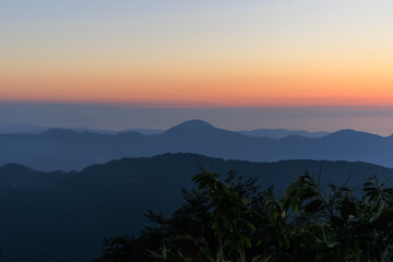 Fototapeta premium Landscape horizon line in the mountains, orange sunset and blue mountains.