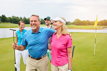 Happy, mature couple and golf outdoor with friends for fitness challenge, talking or support of...