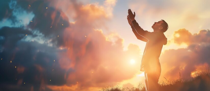 Prayer raises his hands to sunshine or sunset, christian concept background. A man praying to God in the field, his arms up to the sky. Talking to God.